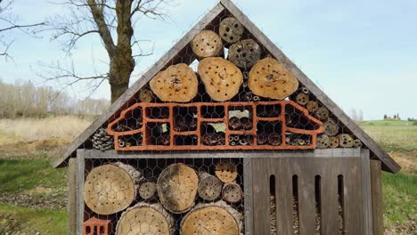 large man made insect hotel amongst trees and shadows