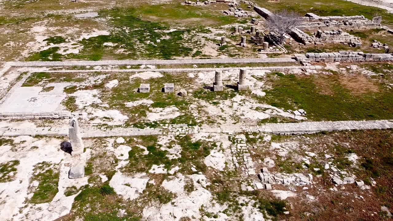 Explore ancient ruins that tell stories of the past in a vast historical site under the sun. The area showcases remnants of columns, walls, and pathways, inviting discovery and reflection