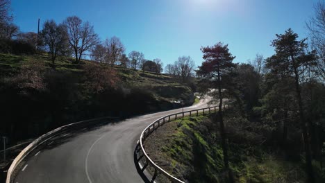 Scenic-winding-road-in-the-Tavertet-region,-Barcelona,-on-a-sunny-day,-surrounded-by-trees