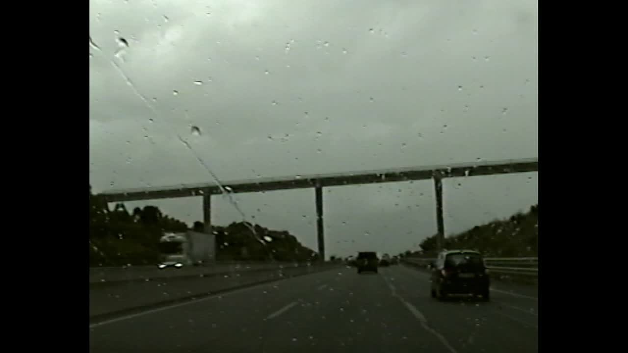 Road with cars and viaduct on an overcast and rainy day