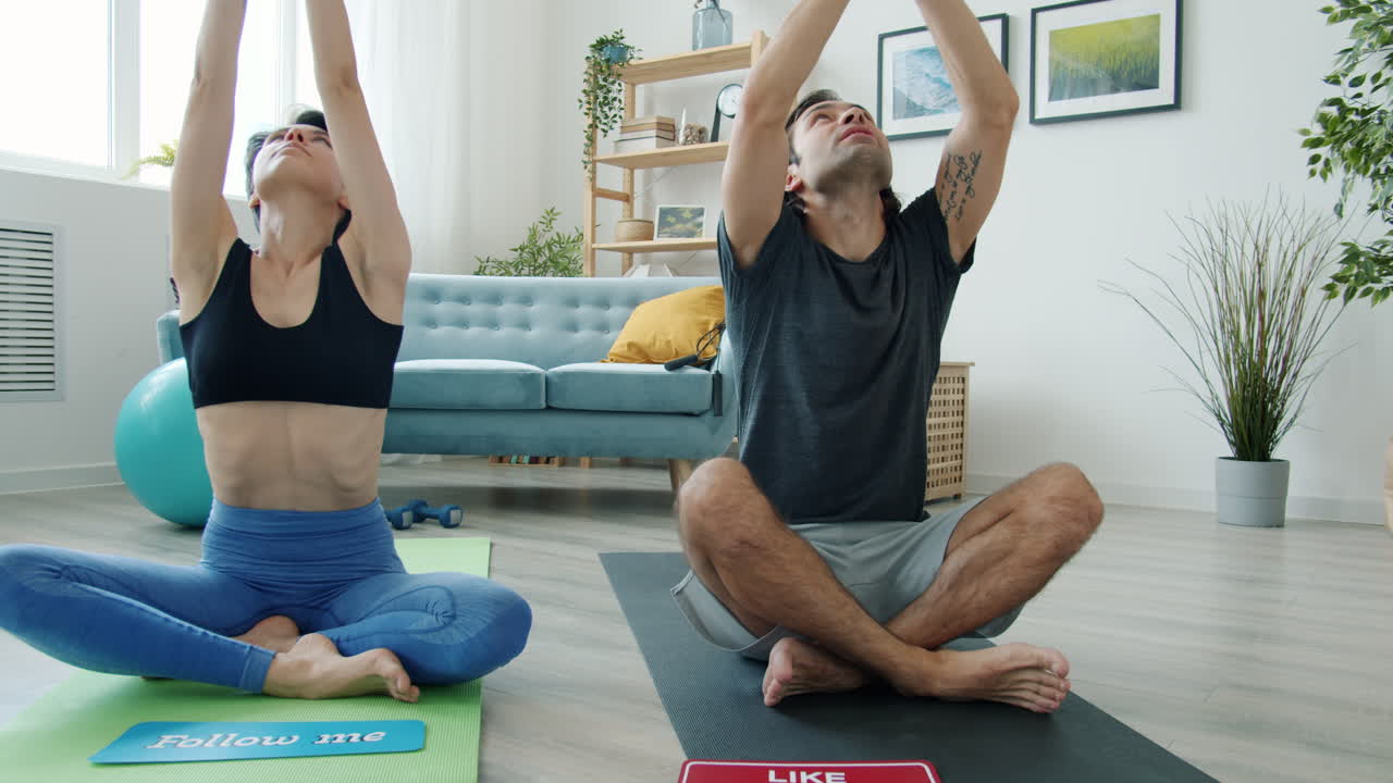 Couple practicing yoga at home and promoting social media content