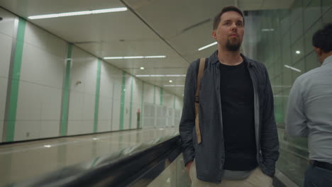 hombre caminando en una escalera mecánica del metro