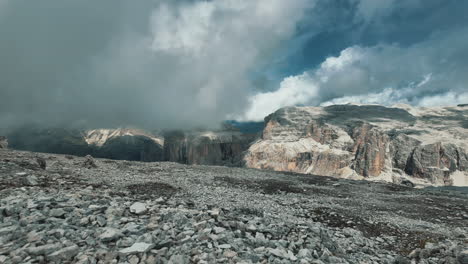 dramatic cloudscape racing over rocky pordoi pass terrain, capturing dynamic atmospheric movement across dolomites mountain landscape in timelapse sequence