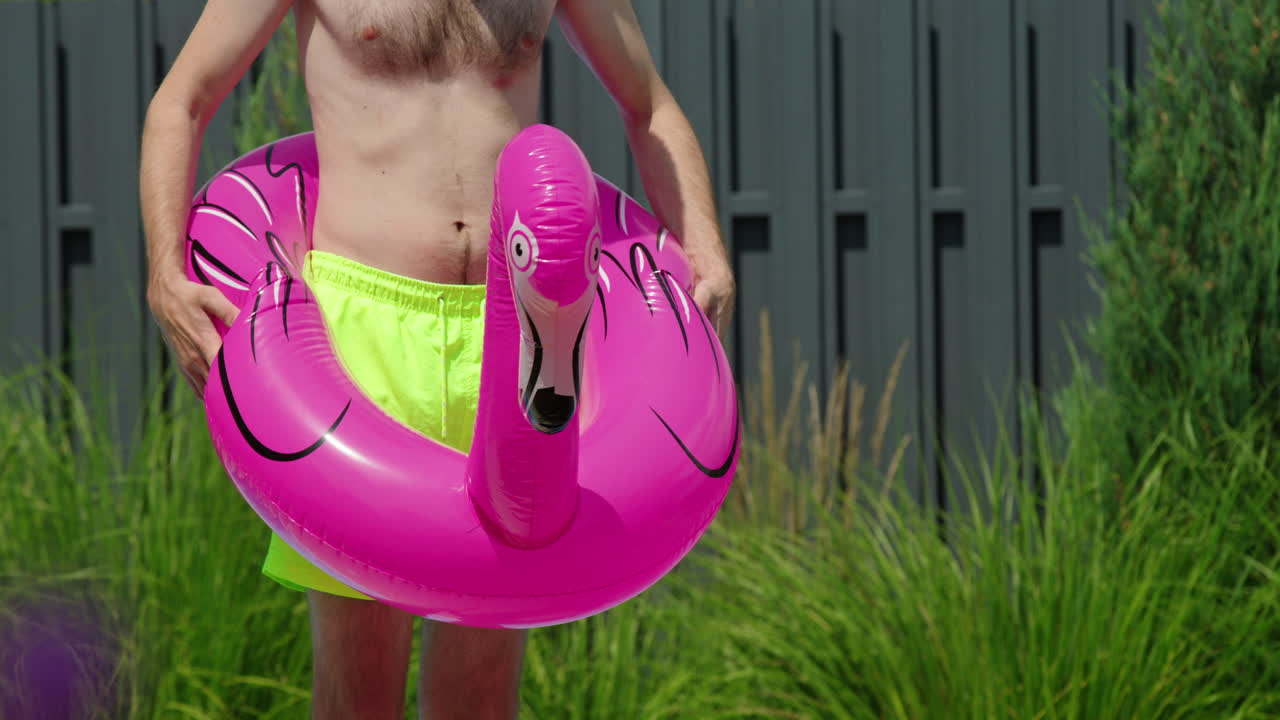 hombre con flamenco flotando en la piscina