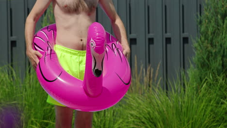 man with flamingo pool float