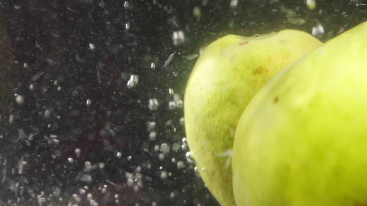 dos peras cayendo en una jarra de agua densa