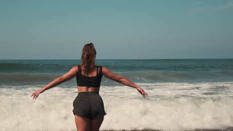 mujer disfrutando de las olas en la playa