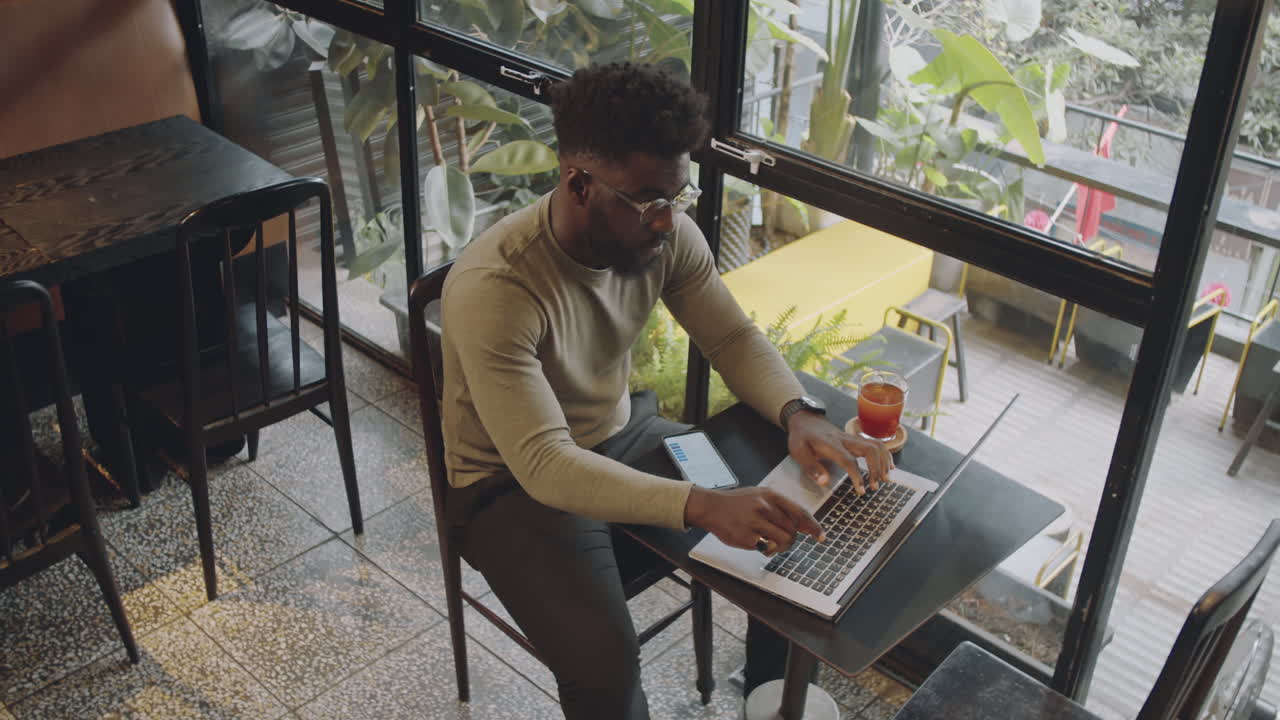 Man working on laptop in a cafe