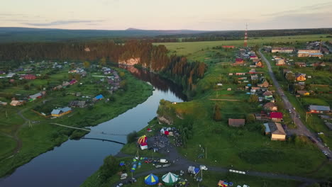 aerial view of a rural village with a river and an event