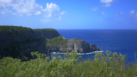 view from a clifftop of the blue caribbean sea and the island of guadeloupe