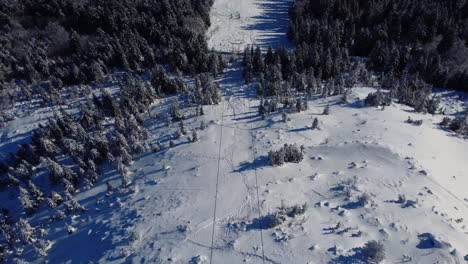 Aerial-drone-revealing-view-of-Liberec-Jested-cableway-track-and-ski-slope,-beautiful-day-and-city-in-background