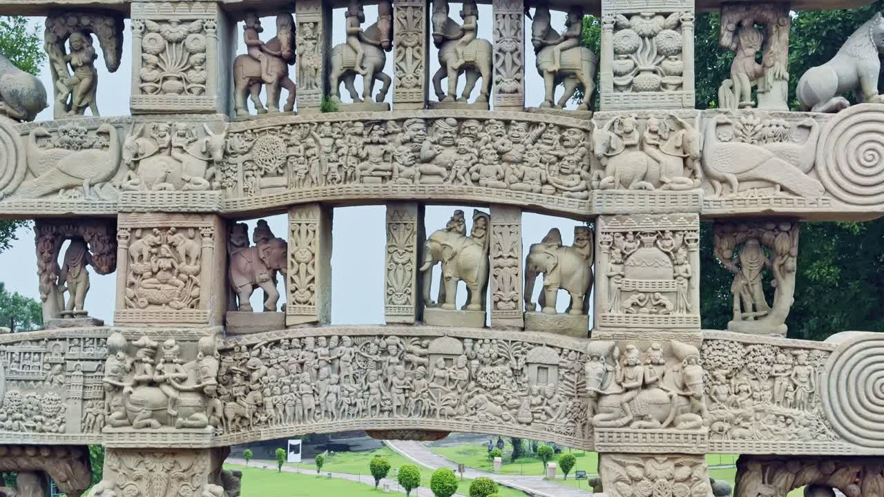 As the camera tilts up, the Torana of Sanchi Stupa unfolds from elephant-carved bases to upper panels, revealing detailed carvings of processions, animals, and sacred symbols of Buddhist heritage