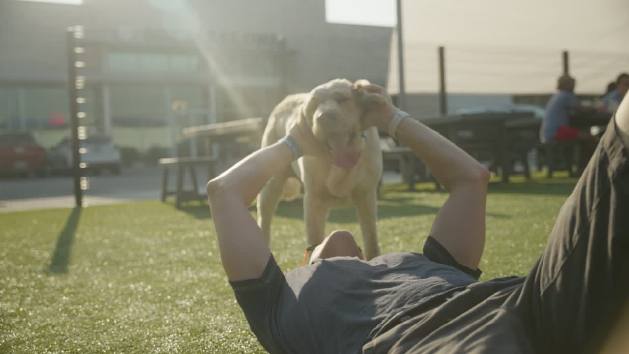 한 남자가 야외 도시 개 공원에서 개와 함께 놀고 있다