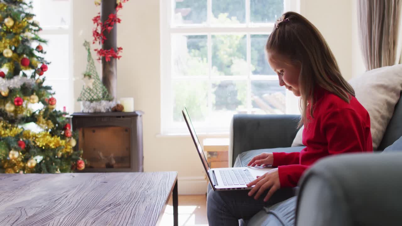 Caucasian girl waving while having a video call on laptop sitting on the couch at home