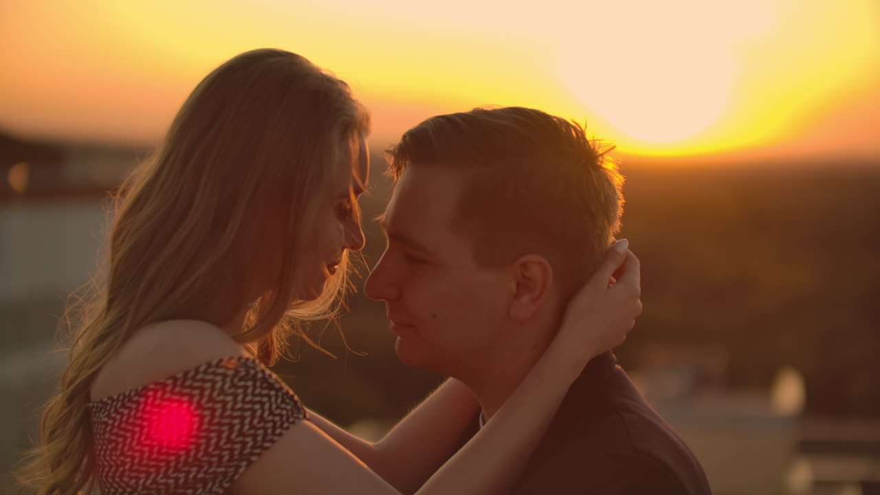 Romantic date on the roof. Loving couple dating on the roof at the sunset