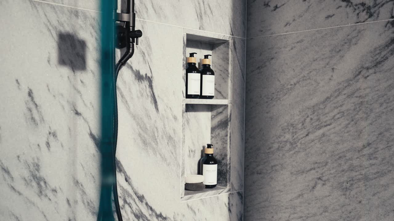 shower accessories in a white granite shower including shampoo conditioner and body wash, push in shot