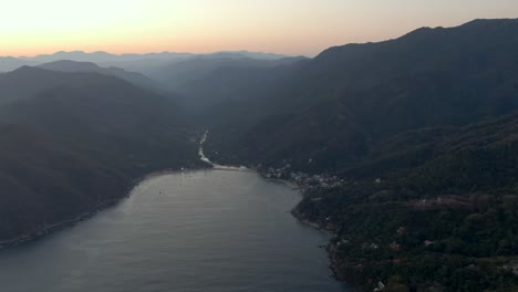 tropical mountain forest with secluded paradise beach on misty morning in yelapa, jalisco, mexico. aerial wide shot