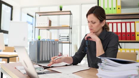 woman focused on paperwork at an office desk