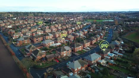 green electric car charging symbols flashing above rural british neighbourhood houses, aerial view descending