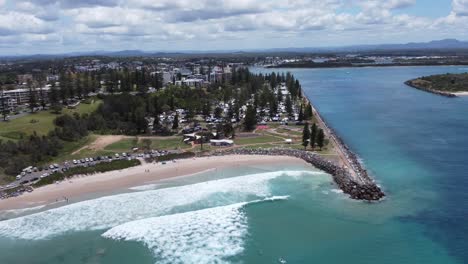 Vista-Aérea-De-Una-Hermosa-Playa-En-El-Parque-De-Caravanas-De-Australia-Y-El-Río-Al-Fondo