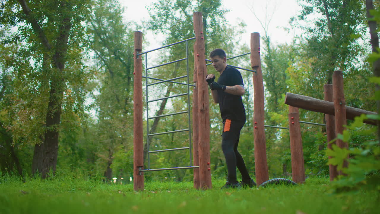 park obstacle boxing drill session with man practicing dynamic combos around wooden posts, energetic footwork and rapid jabhook sequences, sweat and intensity, youthful coach persona, outdoor circuit