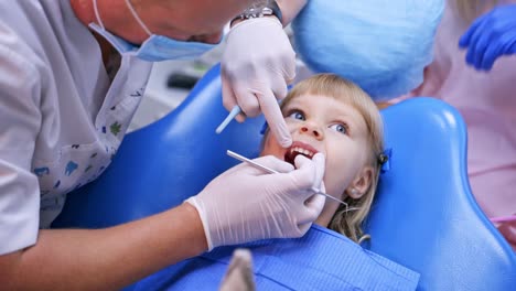 Little child in stomatology chair points at the ill tooth with a finger - close up video. Healthy teeth concept video.