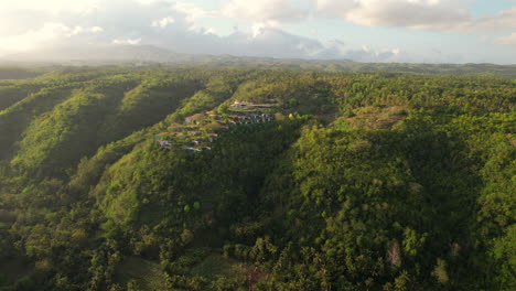 Paisaje-Aéreo-Del-Amanecer-Del-Resort-En-La-Cima-De-Una-Colina-En-Nusa-Penida-Bali-Con-El-Horizonte-Del-Valle-Montañoso-En-El-Desierto-Tropical-De-Indonesia