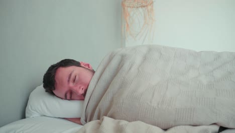 sleeping man, caucasian white with beard, young man lying in bed sleeping dreaming, uncomfortable pillow, turn over in sleep