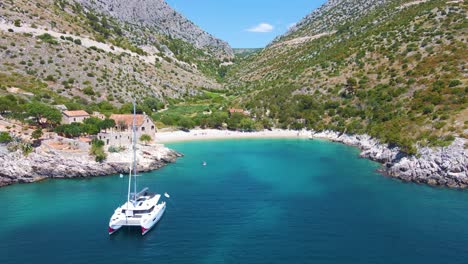 Drifting-yachts-in-the-bay-near-the-coastal-city-of-Croatia-against-the-backdrop-of-blue-skies-and-blue-transparent-water