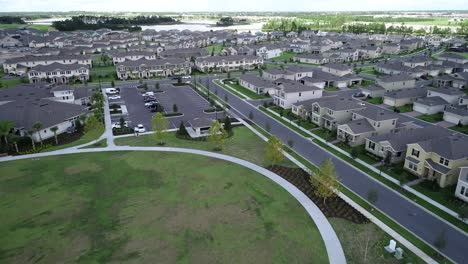 aerial view of an upper middle class lakefront neighborhood subdivision with single family homes and townhouses, pool and clubhouse on a cloudy fall day in winter garden, florida, usa