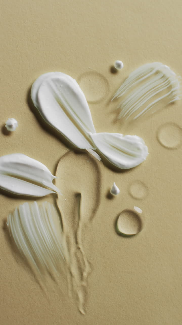 Vertical video of beauty product cream smudges with copy space on yellow background