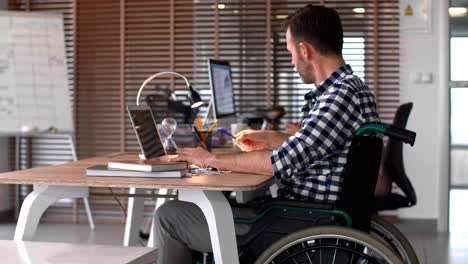 Side-view-of-man-using-laptop-in-office