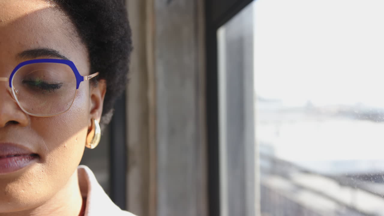 Wearing glasses, woman looking out window, reflecting on business ideas, copy space