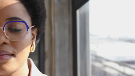 wearing glasses, woman looking out window, reflecting on business ideas, copy space