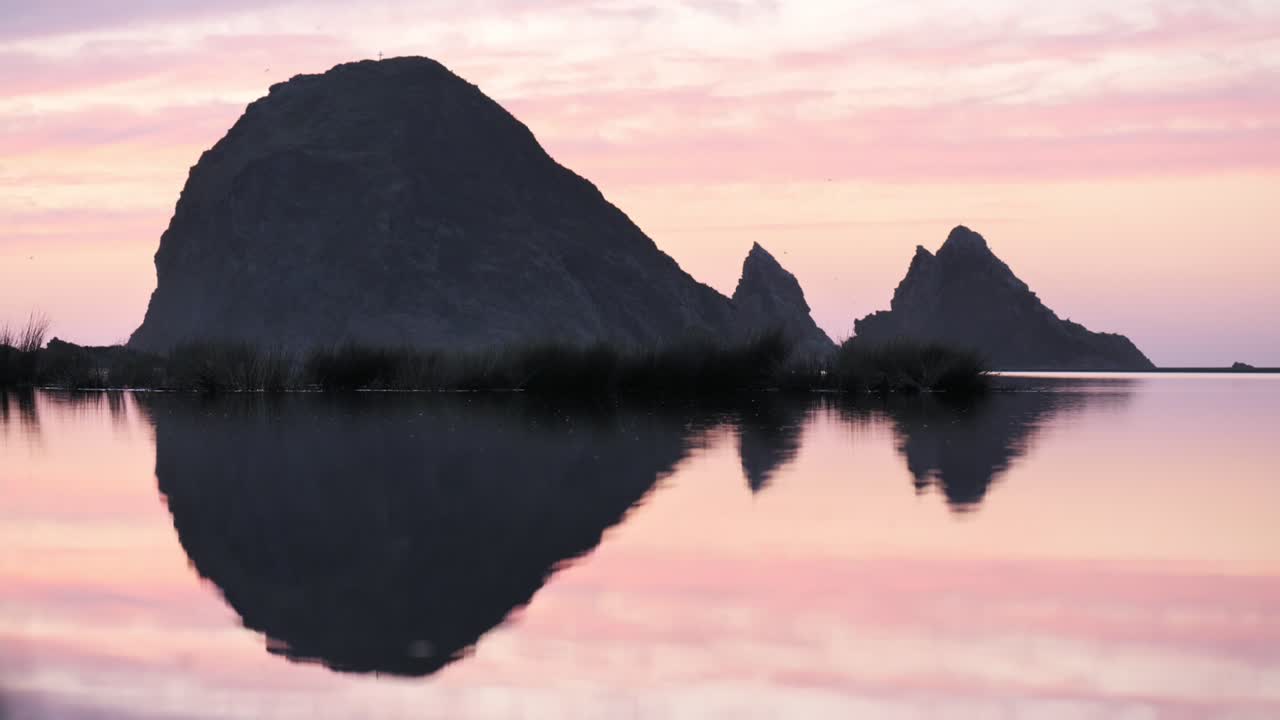 Epic rock formation reflected on the water.