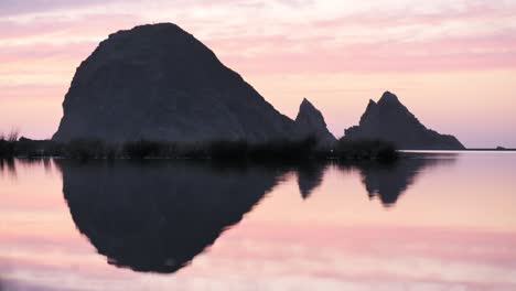 epic rock formation reflected on the water.