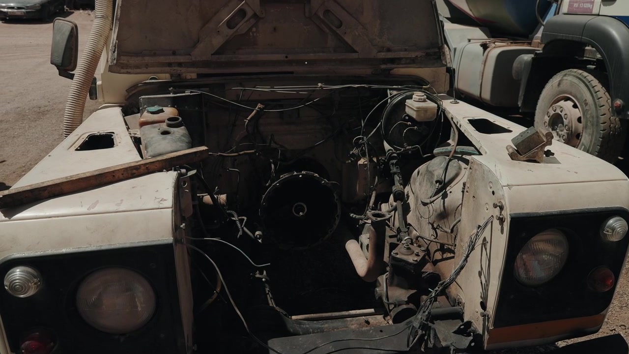 Open hood reveals stripped engine bay of an abandoned off road vehicle in Morocco
