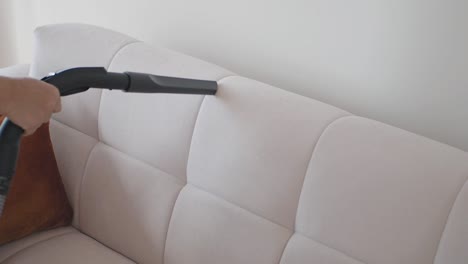 cleaning a couch with a vacuum cleaner