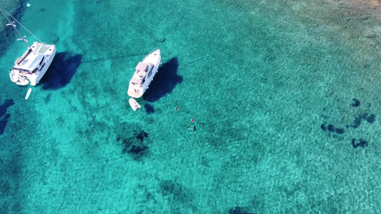 mujer nadando al lado de un catamarán anclado en el agua transparente turquesa de la laguna azul en la isla de veliki budikovac, croacia