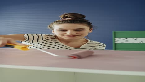 Handheld-video-of-woman-repainting-old-furnitures-with-a-roller.