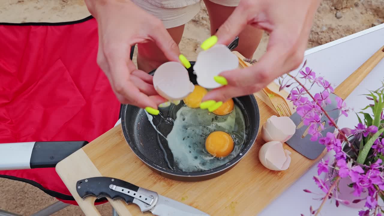 Rustic egg dish next to a clean pocket knife and purple wildflowers, top view