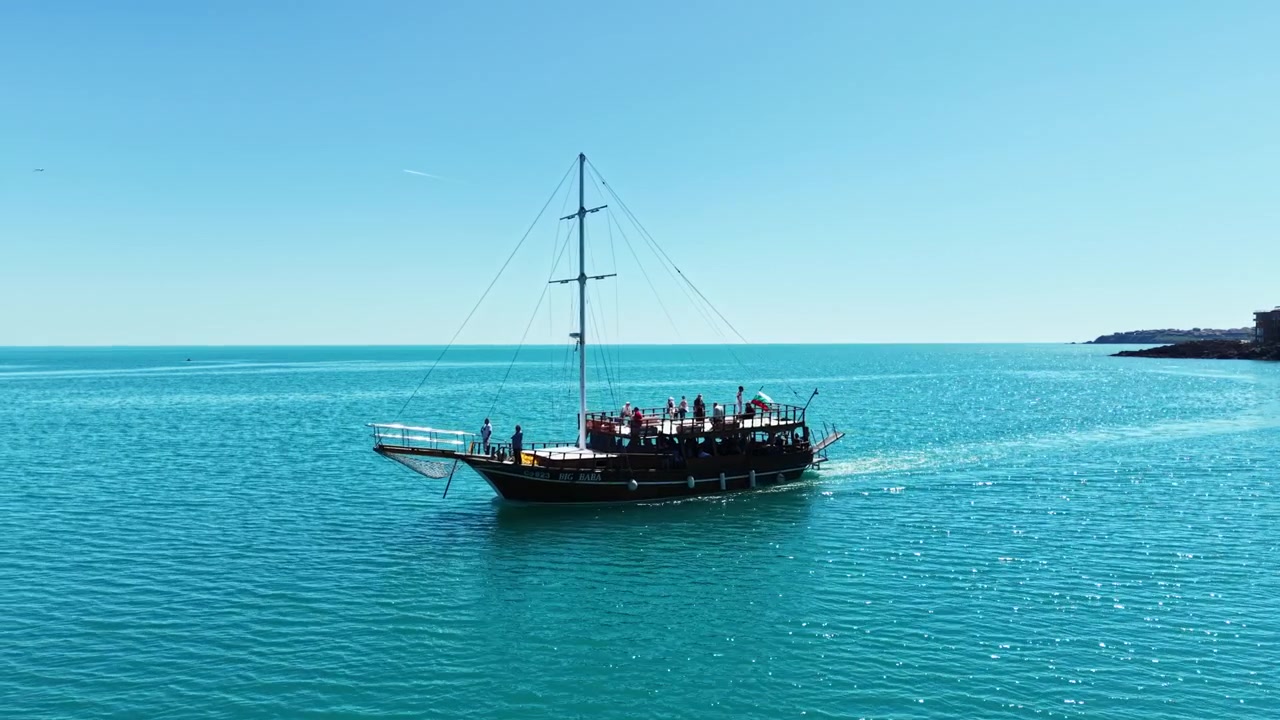 Navigazione su acqua limpida e blu vicino alla costa con una nave che trasporta persone che si godono la giornata di sole