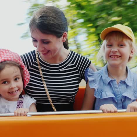 a young mother with two children is riding an attraction