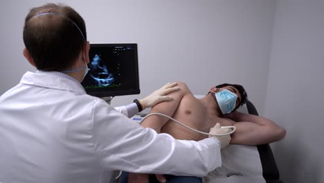 doctor examining heart of patient with ultrasound equipment