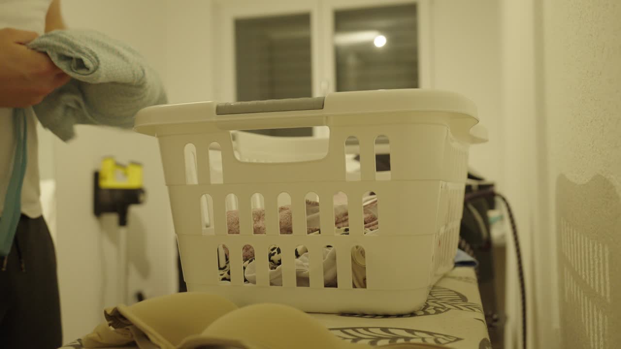 A man sorts and does laundry at home, showing daily household chores and cleanliness