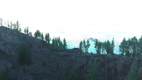 Aerial-view-crossing-the-Pinos-de-Galdar-caldera-during-sunset-and-revealing-a-sea-of-​​clouds-and-fantastic-forests