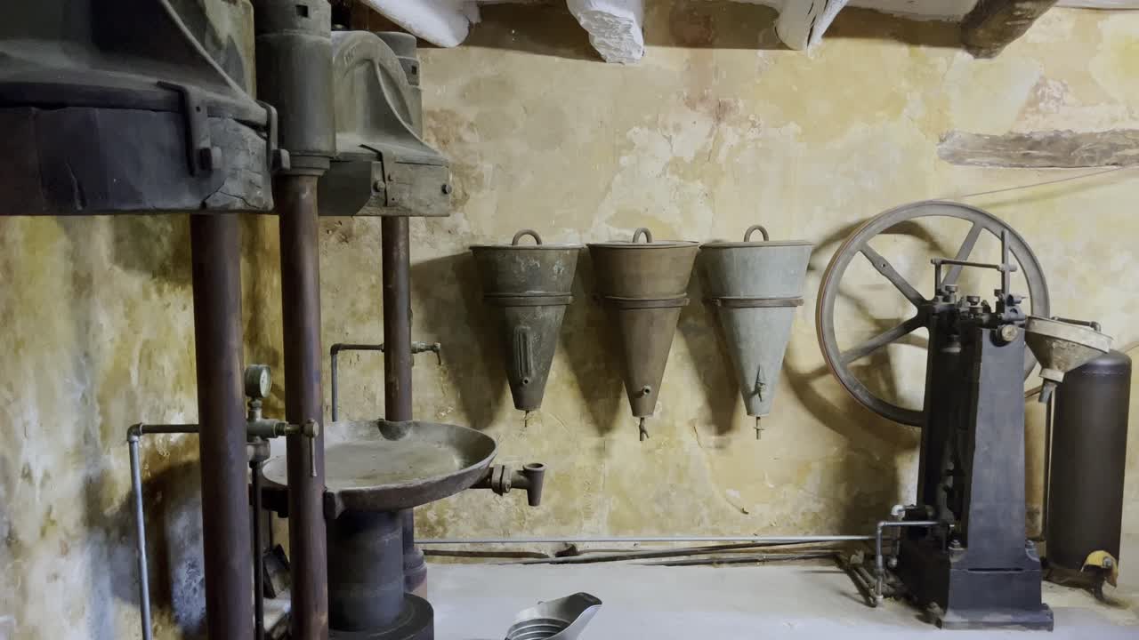 Tools of an old workshop in France for pressing olives for vinegar and oil or pressing for wine with old wooden funnels in a small room
