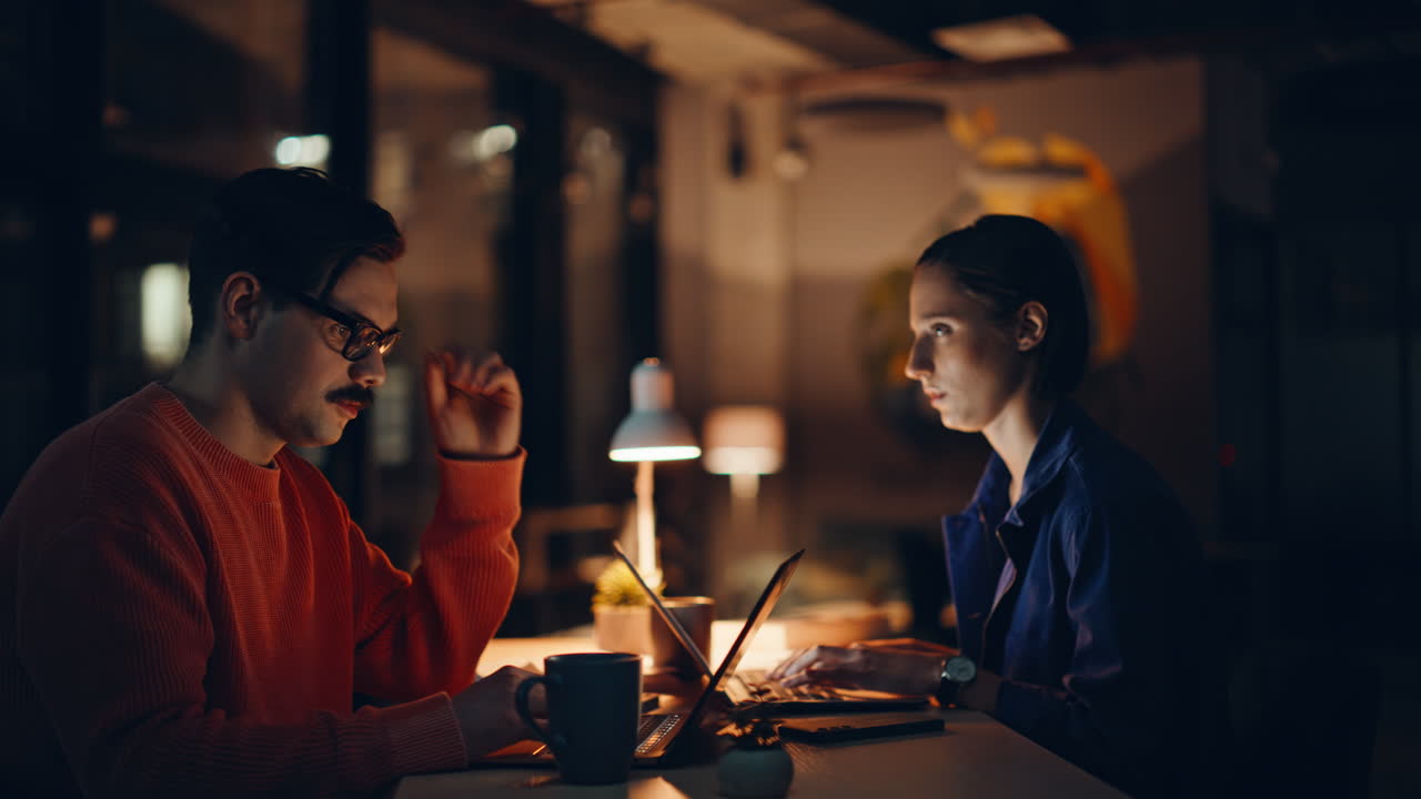 Overworked managers looking laptops at night workspace closeup. Tensed team
