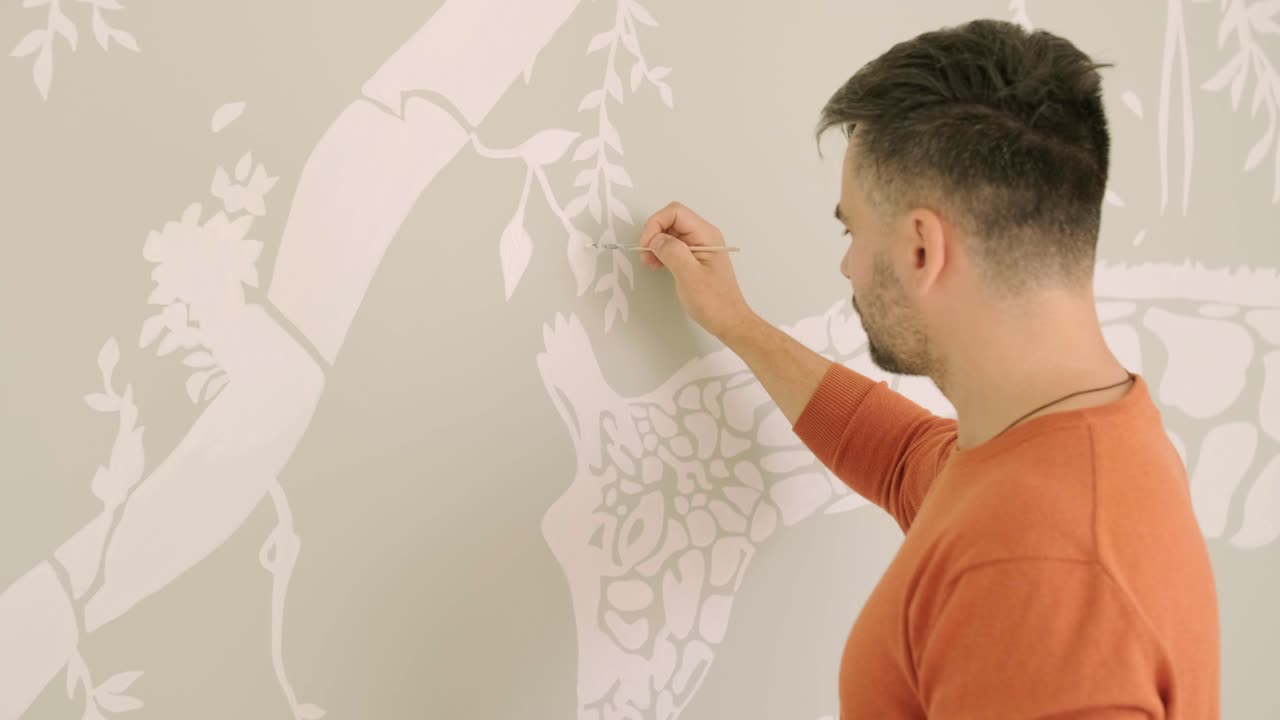 L'artista decora le pareti con disegni nella cameretta dei bambini. Pittura artistica delle pareti nella nuova casa. Lavori di ristrutturazione