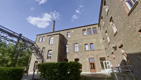 Stillgelegtes-Historisches-Fabrikgebäude-Mit-Stein-Und-Rohren,-Heute-Eine-Jugendherberge-Im-Landschaftspark-Duisbrug-In-Deutschland-Bei-Gutem-Wetter-Mit-Schönen-Großen-Fenstern